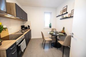 una piccola cucina con tavolo e una piccola sala da pranzo di Bloßfeld-Apartments Geräumige Stadtoase mitten im Zentrum mit 3 Schlafzimmern, Gratis Parkplatz, W-Lan, Netflix a Jena Altre 8 foto