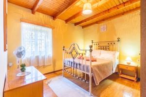1 dormitorio con cama de metal y ventana en Sinarades Village House, en Sinarádes