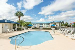 uma piscina com cadeiras e um hotel em Days Inn by Wyndham Valdosta I-75 em Valdosta