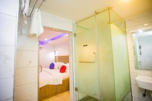 a bathroom with a shower and a bed and a sink at WELLINGTON HOTEL LIMITED in Effurun