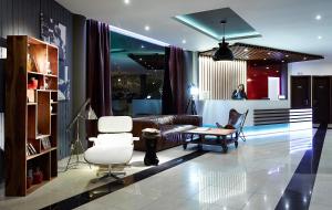 a living room with a couch and two chairs at Trypiti Resort Blue Dream Palace and Hive Water Park in Limenaria