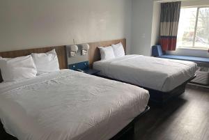 a hotel room with two beds and a window at Microtel Inn by Wyndham Atlanta Airport in Atlanta