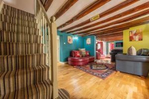 a living room with blue walls and a staircase at Cheney Hollow in Heacham