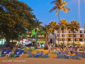 un grupo de sillas y palmeras en una playa en Mandala Beach Villa Jomtiean en Jomtien Beach