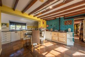 a kitchen with white cabinets and a table with chairs at Cheney Hollow in Heacham