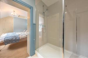 a bathroom with a shower and a glass door at Cheney Hollow in Heacham +32 photos