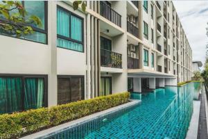 a swimming pool in front of a building at Private apartment Zcape2 near Boat Avenue in Bang Tao Beach