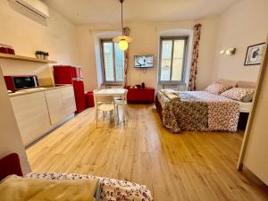 a room with two beds and a table and a kitchen at Alla Scalinata del Teatro Rossetti confort suites parcheggio in Viale XX Settembre in Trieste