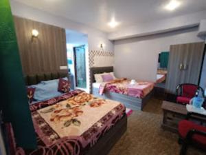 Cette chambre comprend 2 lits et un miroir. dans l'établissement Shiv Inn Stay Darjeeling, à Darjeeling