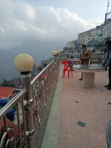 a connaissance d'un bâtiment avec une personne assise à une table dans l'établissement Shiv Inn Stay Darjeeling, à Darjeeling
