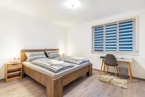 1 dormitorio con cama, escritorio y ventana en Ferienhaus Burghalde mit Sauna, en Alpirsbach