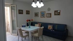 a living room with a table and a blue couch at Appartamento Sanaccara by Holiday World in Alghero