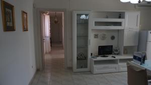 a living room with white cabinets and a television at Appartamento Sanaccara by Holiday World in Alghero