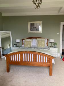 ein Schlafzimmer mit einem großen Bett und einem großen Spiegel in der Unterkunft Goss Hall Bed & Breakfast in Sandwich