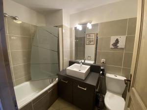 La salle de bains est pourvue d'un lavabo, de toilettes et d'une baignoire. dans l'établissement les 7 laux immobilier chalet D, à Prapoutel
