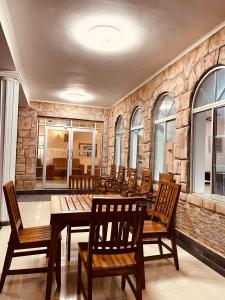 un restaurant avec des tables et des chaises en bois et un mur en pierre dans l'établissement VIP Hotel And Villa, à Beruwala