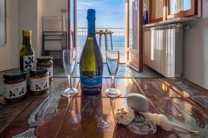 CipressaにあるProfumo di Mareのワイン1本とワイングラス2杯(テーブル上)