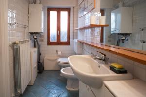 Baño blanco con lavabo y aseo en Profumo di Mare, en Cipressa