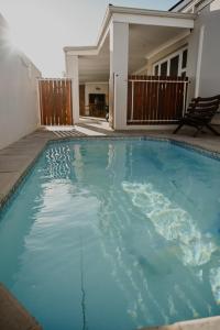 a swimming pool in front of a house at Gecko Lodge in Robertson