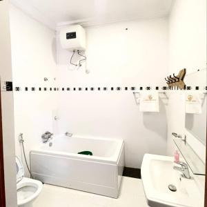 a white bathroom with a sink and a toilet at Avrum Homes in Abuja