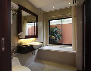 a bathroom with a tub and a sink and a bath tub at Best Western Kuta Villa in Kuta