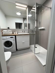 ein Badezimmer mit Waschmaschine und Waschmaschine in der Unterkunft Apartament Marina Bay & SPA in Dziwnów
