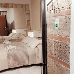 a bedroom with two beds and a brick wall at B&B La casa di Anna in Teano