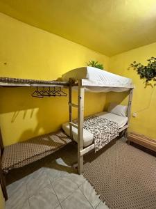 a room with two bunk beds in a yellow wall at Casa du CéSaR in Fortaleza