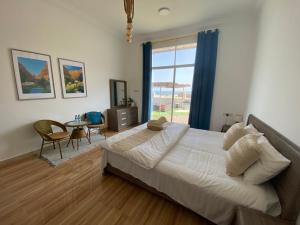 a bedroom with a large bed and a table with chairs at Wadi shab guest house in Ţīwī