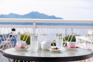 une table avec des verres et des bols de nourriture sur un balcon dans l'établissement Zoe Seaside, à Loutra Edipsou