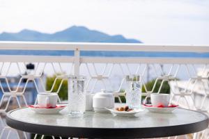 a table with glasses and bowls of food on a balcony at Zoe Seaside in Loutra Edipsou