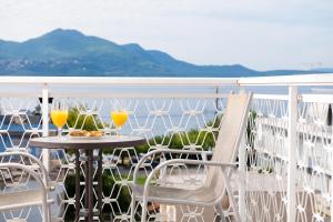 una mesa con 2 vasos de zumo de naranja en el balcón en Zoe Seaside, en Loutra Edipsou