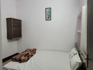 Cette chambre blanche dispose d'un lit et d'une horloge murale. dans l'établissement Hotel Samman, à Siwān