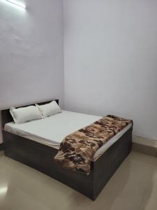Ce lit se trouve dans un dortoir doté d'un mur blanc. dans l'établissement Hotel Samman, à Siwān