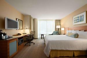 a hotel room with a bed and a desk and a television at Hilton Garden Inn Baltimore Inner Harbor in Baltimore