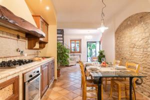 a kitchen with a table and a stone wall at Agriturismo La Valle A Polvereto in Tavarnelle Val di Pesa