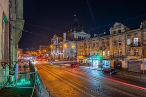 a city street at night with cars and buildings at Your sweet home in Lviv Near Opera in Lviv
