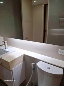 a bathroom with a white toilet and a large mirror at LIV@5 Condominium in Makkasan