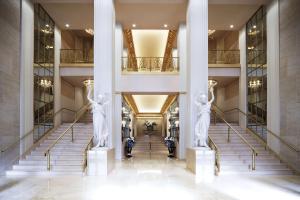 two statues in the lobby of a building with stairs at Waldorf Astoria New York in New York