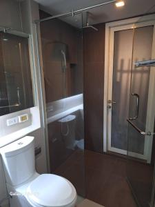 a bathroom with a toilet and a glass shower at LIV@5 Condominium in Makkasan
