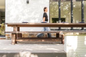 a woman walking past a wooden picnic table at Bunker 155 in Ostend