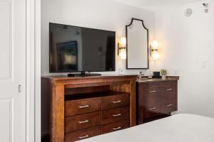 a bedroom with a dresser with a television on it at Embassy Suites by Hilton Los Angeles International Airport South in El Segundo