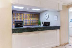 a bar in a hotel lobby with a clock on the wall at La Quinta by Wyndham Chicago Gurnee in Gurnee