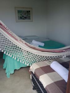 1 dormitorio con 1 cama con mosquitero y toallas. en Vida Gostosa Pousada, en São Miguel do Gostoso