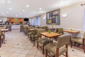 un comedor con mesas y sillas en un restaurante en La Quinta by Wyndham Chicago Gurnee, en Gurnee