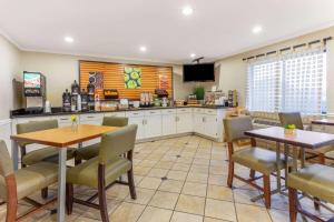 cocina con 2 mesas y sillas y TV en La Quinta by Wyndham Chicago Gurnee, en Gurnee