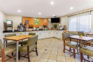 a kitchen with two tables and chairs and a tv at La Quinta by Wyndham Chicago Gurnee in Gurnee