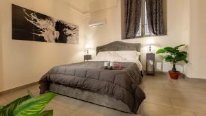 a bedroom with a bed and two lamps and a plant at Duomo Luxury Suite Catania in Catania