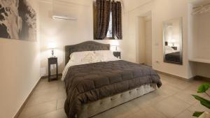a bedroom with a large bed and a mirror at Duomo Luxury Suite Catania in Catania