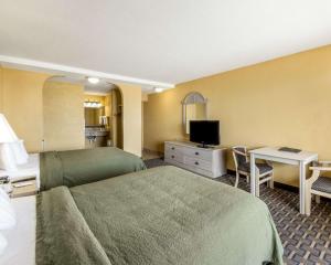 een hotelkamer met een bed en een bureau bij Quality Inn & Suites on the Beach in Corpus Christi